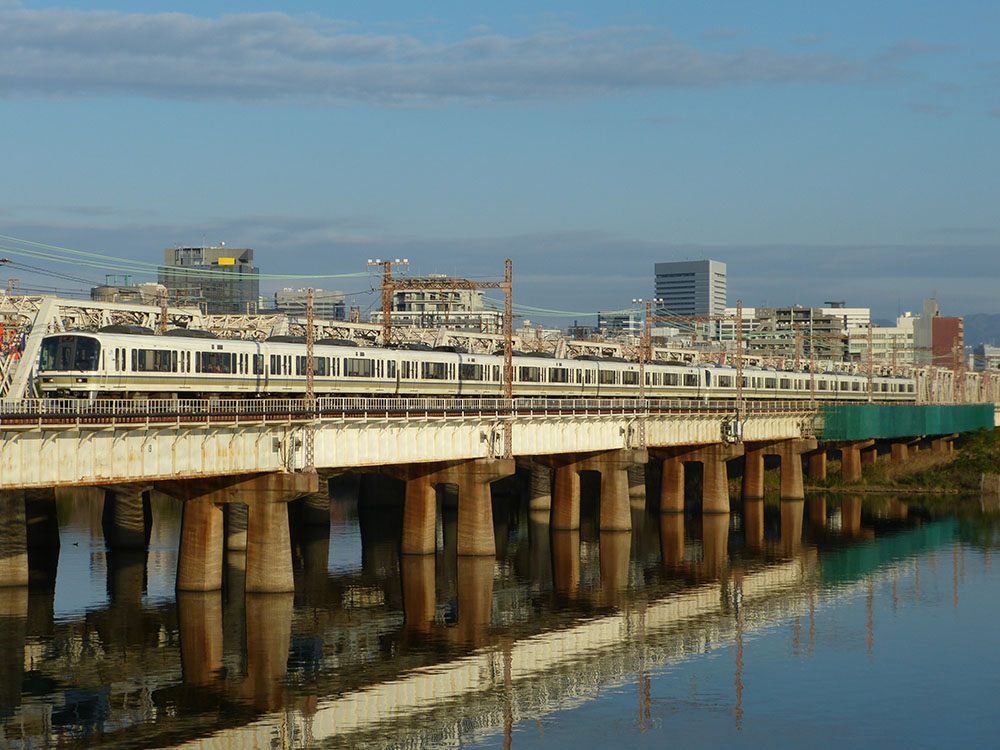 朝陽を浴びて上淀川鉄橋を渡る221系12連