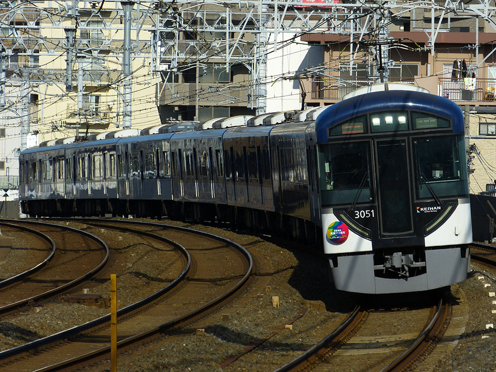 京阪電鉄開業111周年記念ヘッドマークを掲げて走る3000系3001F